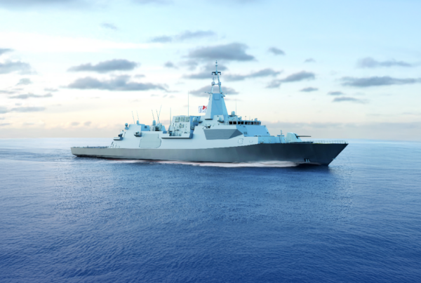 Naval warship sailing on calm blue sea under a clear gradient sky with scattered clouds