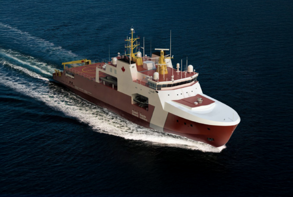 Aerial view of a large Canadian Coast Guard ship sailing in deep blue ocean, white and red hull trailing a wake behind it.