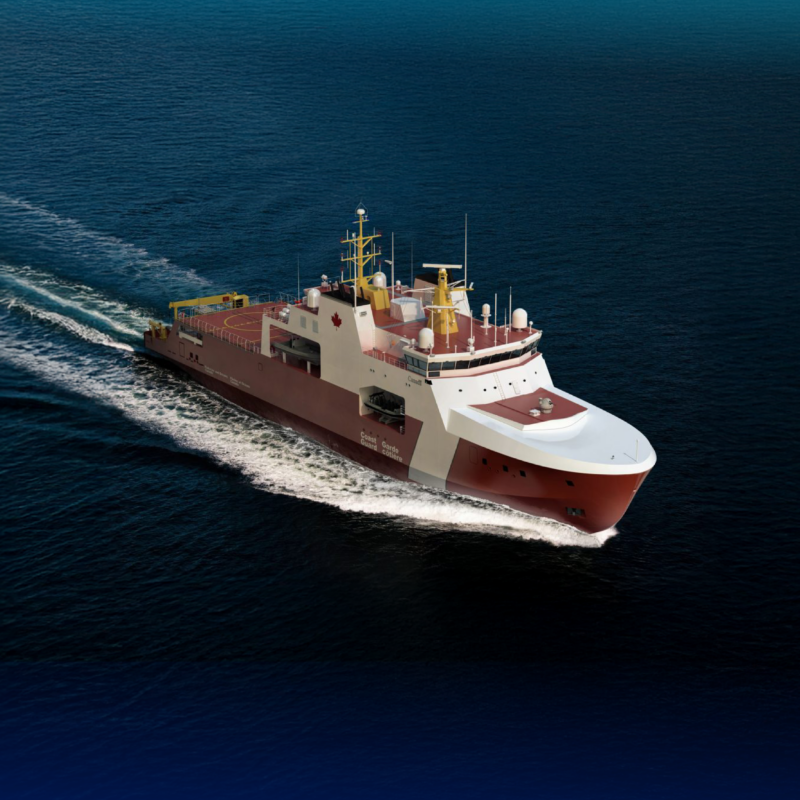 Aerial view of a large Canadian Coast Guard ship sailing in deep blue ocean, white and red hull trailing a wake behind it.